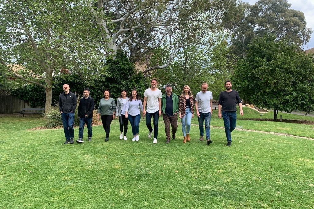 Sherlok team members walking on the grass outside their office
